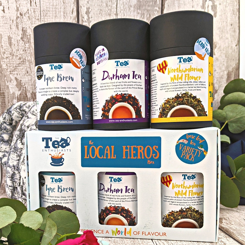 Puede incluir: Una caja de t&eacute; de hoja suelta con tres variedades diferentes: Tyne Brew, Durham Tea y Northumbrian Wild Flower. La caja es blanca con una etiqueta azul y blanca que dice "The Tea Enthusiasts" y "The Local Heros".