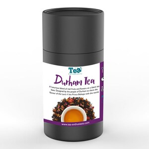 Puede incluir: Un contenedor cil&iacute;ndrico negro con una etiqueta que dice "Tea Enthusiasts Durham Tea". La etiqueta presenta una taza de t&eacute; y una descripci&oacute;n de la mezcla de t&eacute;. El texto en la etiqueta dice: "Una mezcla lujosa de frutas y flores reales sobre una base de t&eacute; negro. Dise&ntilde;ado por la gente de Durham para compartir el sabor de la Tierra de los Obispos Pr&iacute;ncipes con el mundo. www.tea-enthusiasts.com"