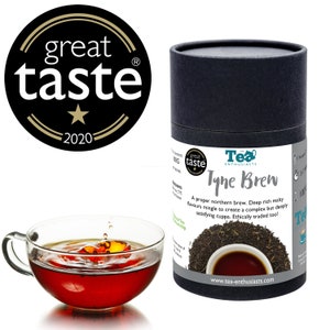 Puede incluir: Un contenedor cil&iacute;ndrico negro de t&eacute; Tyne Brew con una etiqueta en blanco y negro. La etiqueta presenta el texto "Tyne Brew" y el lema "A proper northern brew. Deep rich malty flavours mingle to create a complex but deeply satisfying cuppa. Ethically traded too!" La etiqueta tambi&eacute;n incluye la direcci&oacute;n del sitio web "www.tea-enthusiasts.com".