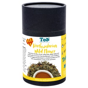 Puede incluir: Un contenedor cil&iacute;ndrico negro con un dise&ntilde;o de coraz&oacute;n amarillo y rojo. El contenedor est&aacute; etiquetado como "The Tea Enthusiasts Northumbrian Wild Flower" y presenta una descripci&oacute;n de la mezcla de t&eacute;. El texto de la etiqueta dice: "Inspirado por la flora de las colinas onduladas, los valles tranquilos y los caminos costeros de la antigua Northumberland. Tierra de folclore, mitos y leyendas encapsuladas en una mezcla de t&eacute; de hierbas que rebosa de flores enteras, hierbas, frutas y hojas."