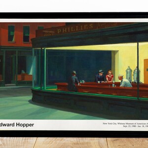 May include: A painting by Edward Hopper titled "Nighthawks" depicting a diner at night with four people sitting at the counter. The diner is lit by bright yellow lights, and the exterior is dark green. The painting is framed in black.