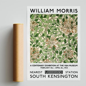May include: A black and white poster advertising a William Morris exhibition at the Victoria and Albert Museum in London, England. The poster features a floral pattern and the text "WILLIAM MORRIS", "A CENTENARY EXHIBITION AT THE V&A MUSEUM", "FEBRUARY 10th - APRIL 8th, 1934", "NEAREST UNDERGROUND STATION", and "SOUTH KENSINGTON".