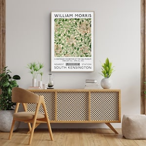 May include: A vintage poster advertising a William Morris exhibition at the V&A Museum in London. The poster features a floral design in shades of green and white. The text reads "William Morris", "A Centenary Exhibition at the V&A Museum", "February 1st - April 30th 1964", "Nearest Underground Station South Kensington".