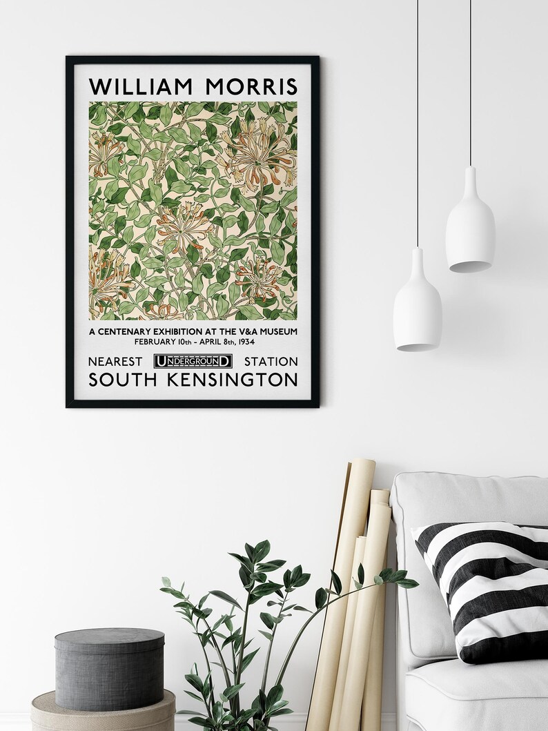 May include: A black and white poster with the text "WILLIAM MORRIS" at the top. The poster features a floral design with green leaves and white flowers. The text "A CENTENARY EXHIBITION AT THE V&A MUSEUM FEBRUARY 10th - APRIL 8th, 1934 NEAREST UNDERGROUND STATION SOUTH KENSINGTON" is at the bottom of the poster.