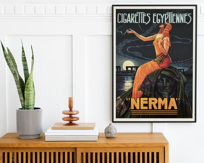 May include: Vintage poster advertising "Nerma" Egyptian cigarettes. The poster features a woman in a flowing orange dress sitting on a sphinx, with a moon and pyramids in the background.