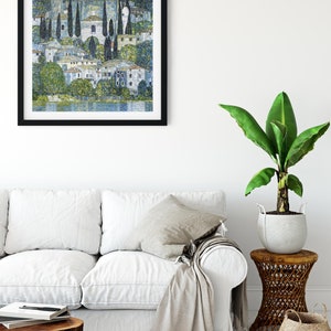 Puede incluir: Una pintura enmarcada de un paisaje con un pueblo y un lago. La pintura est&aacute; realizada en estilo puntillista, con peque&ntilde;os puntos de color que crean la imagen. Los colores son principalmente azul, verde y blanco.