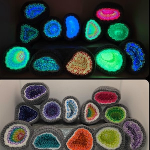 May include: A collection of fourteen crocheted geode-shaped ornaments with gray yarn borders. The centers feature colorful, translucent beads that glow in the dark, displaying vibrant shades of blue, green, pink, orange, and purple.