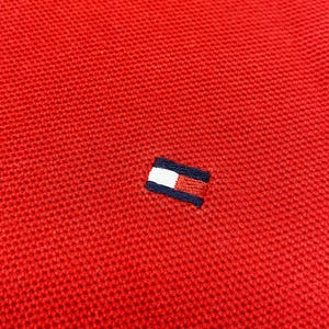 Peut inclure: Polo rouge avec un petit logo brodé représentant un rectangle blanc avec un rectangle rouge à l'intérieur et un contour bleu.