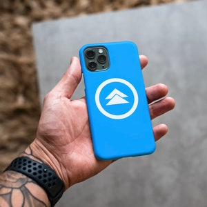 May include: A blue phone case with a white logo of two overlapping triangles inside a circle.
