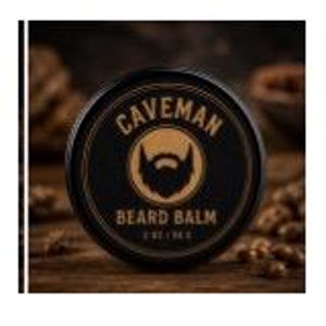 Peut inclure: Une boîte ronde noire de "Caveman Beard Balm" avec un dessin de barbe doré et du texte. La boîte contient 56,6 g de baume. L'arrière-plan est une surface en bois avec des noix floues.