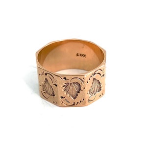 May include: A gold ring with a hexagonal band and a floral design. The inside of the band is marked with "5XX".