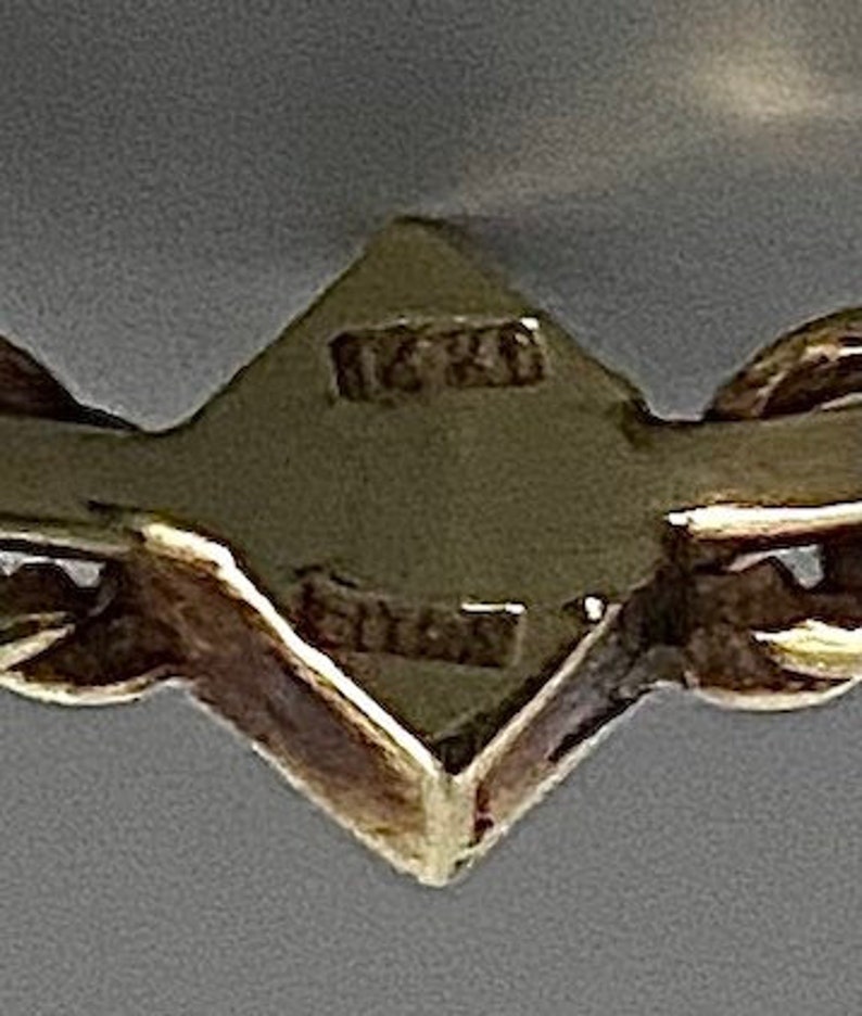May include: Close-up of a gold chain with a diamond-shaped tag that reads "16K" and "Gold".