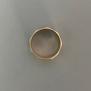 May include: A gold-colored ring with a faceted, octagonal design.