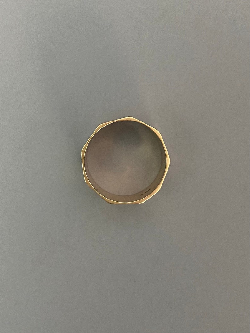 May include: A gold-colored ring with a faceted, octagonal design.