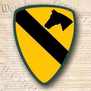 May include: A yellow and black military patch with a green border. The patch features a black silhouette of a horse's head facing left. The patch is shaped like a shield.