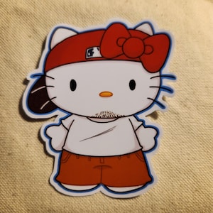Könnte beinhalten: Ein roter und weißer Hello Kitty-Aufkleber mit einer roten Baseballkappe und einem Ziegenbart. Der Aufkleber trägt ein weißes T-Shirt und eine rote Hose.