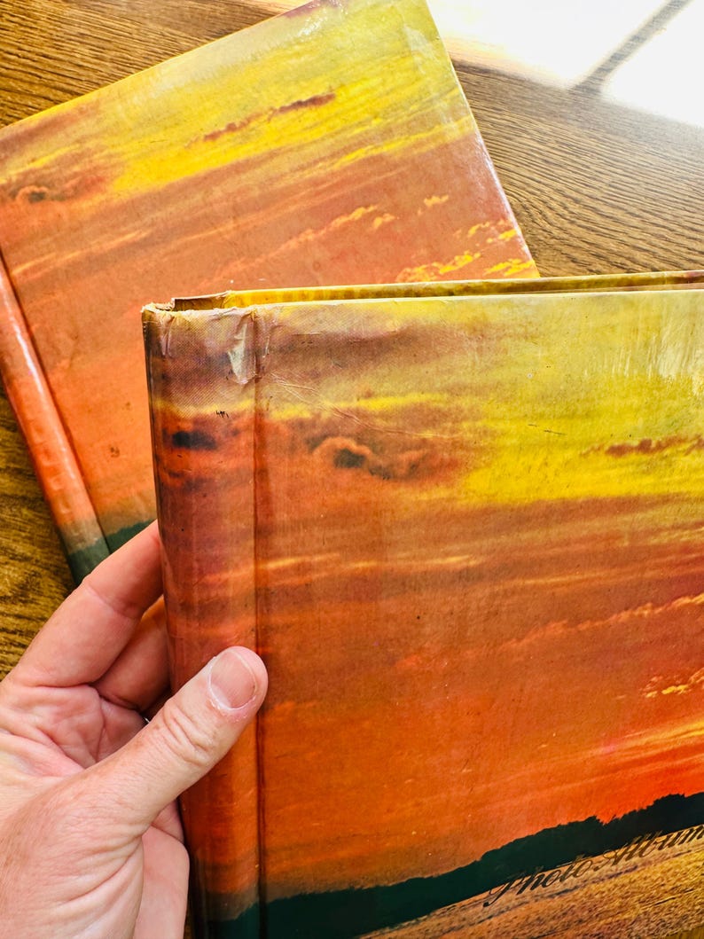 May include: Two hardback books with a sunset scene on the cover. The books are stacked on top of each other. The top book is slightly askew.