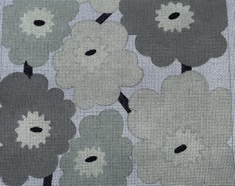 May include: A needlepoint canvas featuring a repeating floral pattern in shades of gray, white, and black. The design consists of large, stylized flowers with rounded petals and dark centers, set against a white grid background.