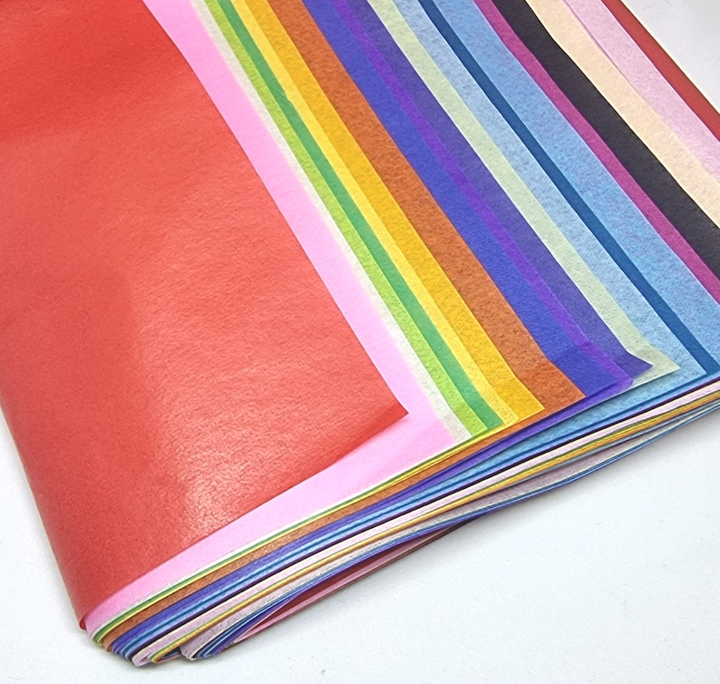 May include: A stack of colorful tissue paper in various shades of red, pink, orange, yellow, green, blue, purple, and white.