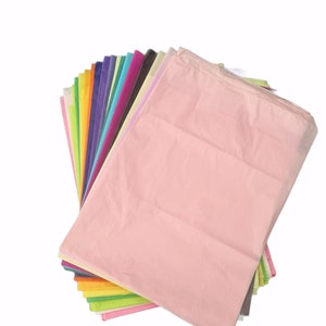 May include: A stack of colorful tissue paper in various shades of pink, purple, blue, green, yellow, orange, and red. The tissue paper is folded and arranged in a fan shape.