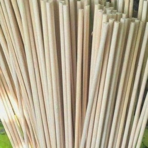 May include: A bundle of natural, unpainted wooden dowels. The dowels are smooth and have a light brown color. They are all the same length and diameter.