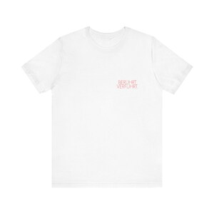 May include: White t-shirt with the text "BERUHRT VERFUHRT" printed in pink on the front.
