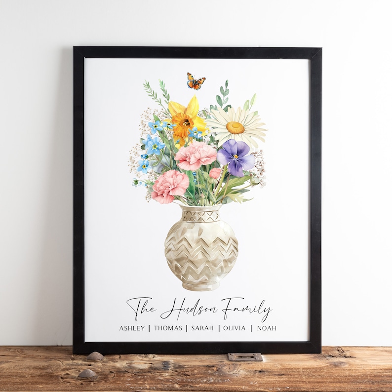 May include: A watercolour print of a bouquet of flowers in a white vase with a butterfly flying above. The flowers are pink, yellow, blue, and purple. The text "The Hudson Family" is below the vase, and the names "Ashley | Thomas | Sarah | Olivia | Noah" are below the text.
