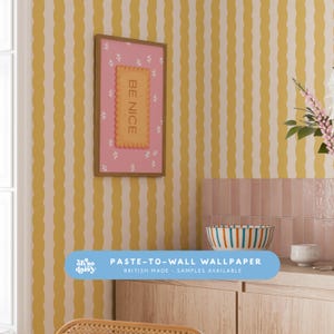 May include: A room featuring yellow and white striped wallpaper. A framed pink print with the words "BE NICE" is displayed. A blue banner at the bottom reads "PASTE-TO-WALL WALLPAPER BRITISH MADE - SAMPLES AVAILABLE".