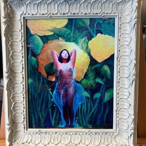 Peut inclure: Peinture encadrée représentant une figure nue entourée de fleurs jaunes et de feuillage vert. La figure est partiellement voilée de bleu. Le cadre blanc présente des détails décoratifs. Thème naturel et éthéré.