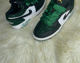 May include: Black and green low-top trainers with a white swoosh and green satin laces. The trainers are covered in rhinestones and have the name "Middleton" written on the side.