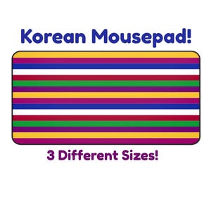 Op de afbeelding: Een rechthoekige muismat met een gestreept patroon in verschillende kleuren, waaronder paars, geel, rood, groen en wit. De tekst "Korean Mousepad!" staat erboven en "3 Different Sizes!" eronder.