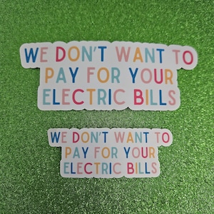 May include: Two white stickers with the text "WE DON'T WANT TO PAY FOR YOUR ELECTRIC BILLS" in colorful letters. The stickers are on a green glitter background.