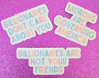 May include: Three die-cut vinyl stickers with pastel-colored text. One reads BILLIONAIRES DONT CARE ABOUT YOU, another says MORONS ARE GOVERNING AMERICA, and the third states BILLIONAIRES ARE NOT YOUR FRIENDS. The letters are in light blue, pink, and purple.