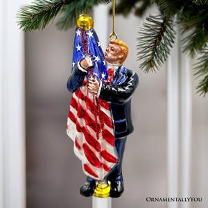 Adorno navideño de cristal de Donald Trump besando la bandera estadounidense, presidente de los Estados Unidos
