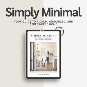 May include: A digital tablet displaying a book cover titled "Simply Minimal: Your Guide to a Clutter-Free, Calm, and Organized Home." The cover features a woman vacuuming in a kitchen with white cabinets and hardwood floors. The book is published by All Things New Home.