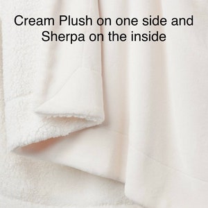 May include: Cream plush throw blanket with sherpa lining. The blanket is folded to show both sides.