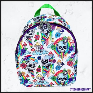 May include: White backpack with a repeating pattern of skulls, rainbows, mushrooms, and flowers in vibrant colors. The backpack has a green handle, purple trim, and silver zippers. The text "ITSSQUIRRELCRAFT" is visible.
