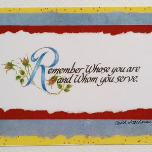 May include: A handmade greeting card with a white center, red border, and blue and yellow background. The card features the text "Remember Whose you are and Whom you serve." The letter "R" is stylized with blue and floral accents.