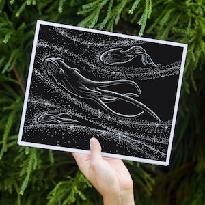 Puede incluir: Ilustración en blanco y negro de tres ballenas nadando en un cielo estrellado. Las ballenas están dibujadas en un estilo simple y elegante, con sus cuerpos delineados en blanco y sus aletas y colas rellenas de negro. Las estrellas están representadas por pequeños puntos blancos dispersos sobre el fondo negro.