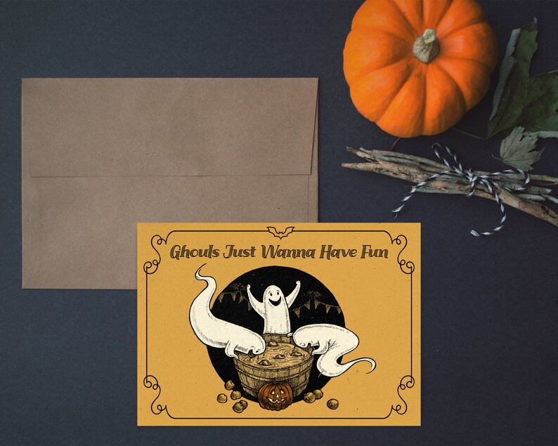 May include: A yellow card with a black border and a black and white illustration of three ghosts in a cauldron. The text on the card reads "Ghouls Just Wanna Have Fun".
