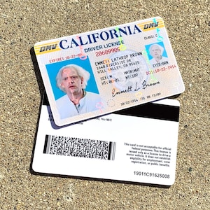 K&ouml;nnte beinhalten: Ein kalifornischer F&uuml;hrerschein mit einem Foto von Emmett Lathrop Brown, der Figur Doc Brown aus der Back to the Future-Filmreihe. Die F&uuml;hrerscheinnummer lautet 20609909 und das Ablaufdatum ist der 10-22-89. Der F&uuml;hrerschein gibt an, dass Emmett m&auml;nnlich ist, 1,55 m gro&szlig; ist, wei&szlig;e Haare und braune Augen hat. Der F&uuml;hrerschein ist nicht f&uuml;r offizielle Bundeszwecke g&uuml;ltig.