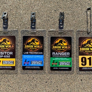 Puede incluir: Cuatro insignias de identificaci&oacute;n transparentes de Jurassic World. Las insignias incluyen los siguientes t&iacute;tulos: Visitante, T&eacute;cnico de laboratorio, Ranger y 916. Cada insignia tiene un esquema de color diferente e incluye el logotipo de Jurassic World.