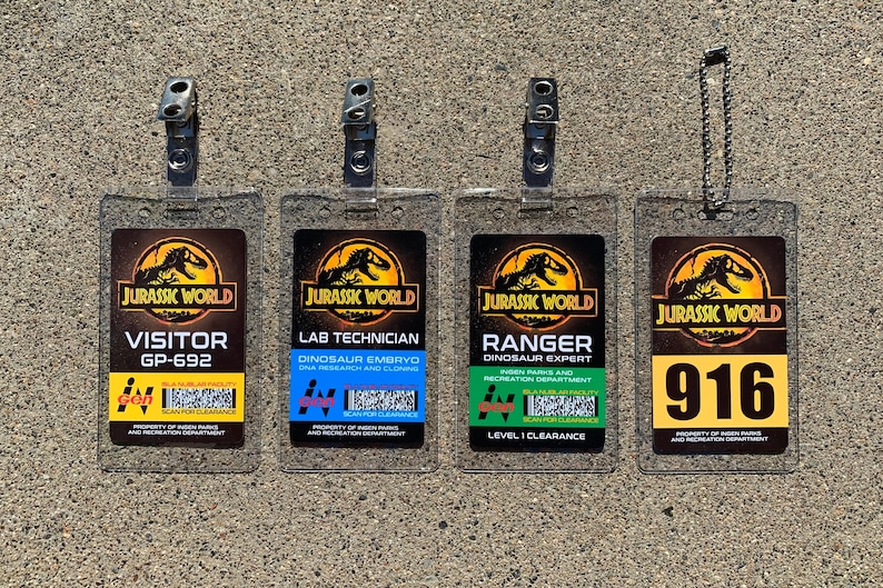 Puede incluir: Cuatro insignias de identificaci&oacute;n transparentes de Jurassic World. Las insignias incluyen los siguientes t&iacute;tulos: Visitante, T&eacute;cnico de laboratorio, Ranger y 916. Cada insignia tiene un esquema de color diferente e incluye el logotipo de Jurassic World.