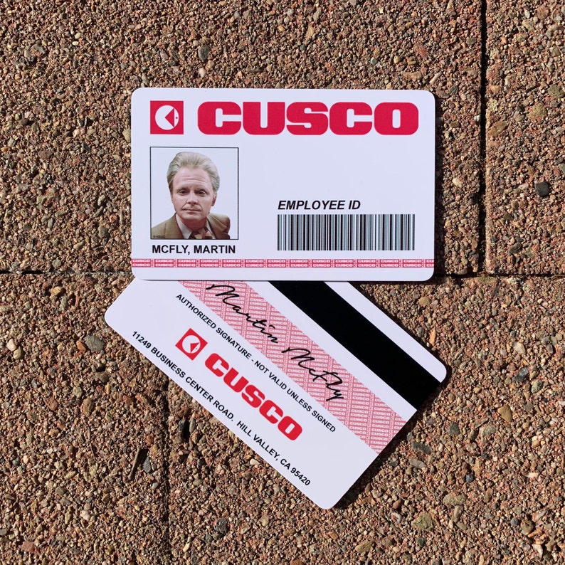 K&ouml;nnte beinhalten: Ein wei&szlig;er Plastik-Mitarbeiter-Ausweis mit einem roten CUSCO-Logo. Die Karte zeigt ein Foto eines Mannes, den Namen "MCFLY, MARTIN" und einen Barcode. Die Karte hat au&szlig;erdem eine rote Signaturzeile mit dem Text "AUTHORIZED SIGNATURE - NOT VALID UNLESS SIGNED" und die handschriftliche Unterschrift "Martin McFly".
