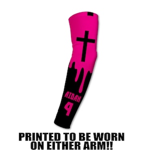 May include: A pink and black arm sleeve with a cross design. The sleeve has a dripping paint effect, with the name "AIDAN" and the number "4" printed on it. The text "PRINTED TO BE WORN ON EITHER ARM!!" is at the bottom.