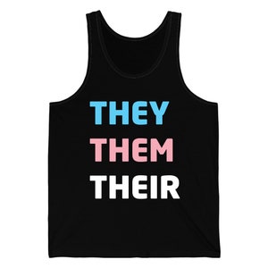 Op de afbeelding: Zwart mouwloos shirt met de woorden "THEY THEM THEIR" in blauw, roze en wit. De tekst is verticaal gerangschikt, elk woord op een aparte regel. Het shirt is mouwloos en gemaakt van een zacht materiaal.