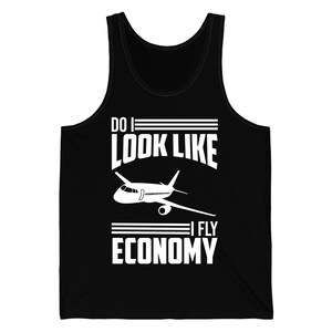Pode incluir: Camiseta preta sem mangas com texto branco e um gráfico de avião. O texto diz "DO I LOOK LIKE I FLY ECONOMY". A camiseta sem mangas é sem mangas e feita de um material macio.