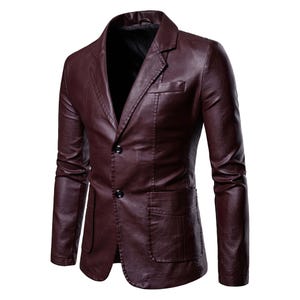 May include: A burgundy leather blazer with a two-button closure, notched lapels, and two front pockets. The jacket has a classic, tailored fit and a smooth, polished finish. The blazer is a stylish outerwear option.