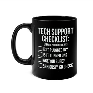Puede incluir: Taza de cerámica negra con texto blanco: "TECH SUPPORT CHECKLIST: (ANTES DE MOLESTARME)". La lista de verificación incluye preguntas sobre energía y conexiones. Un regalo humorístico.