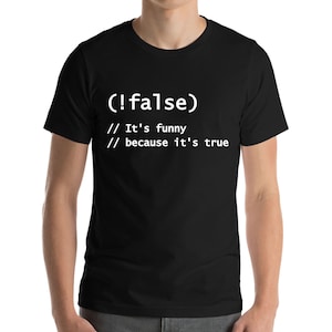 Può includere: T-shirt nero con testo bianco: "(!false) // It's funny // because it's true". La maglietta è a girocollo e maniche corte.
